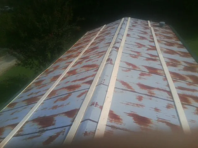Rusted metal roof panels with new wood purlins before replacement — Storm Damage Roof Repair in Kinsale by Roofing Brothers