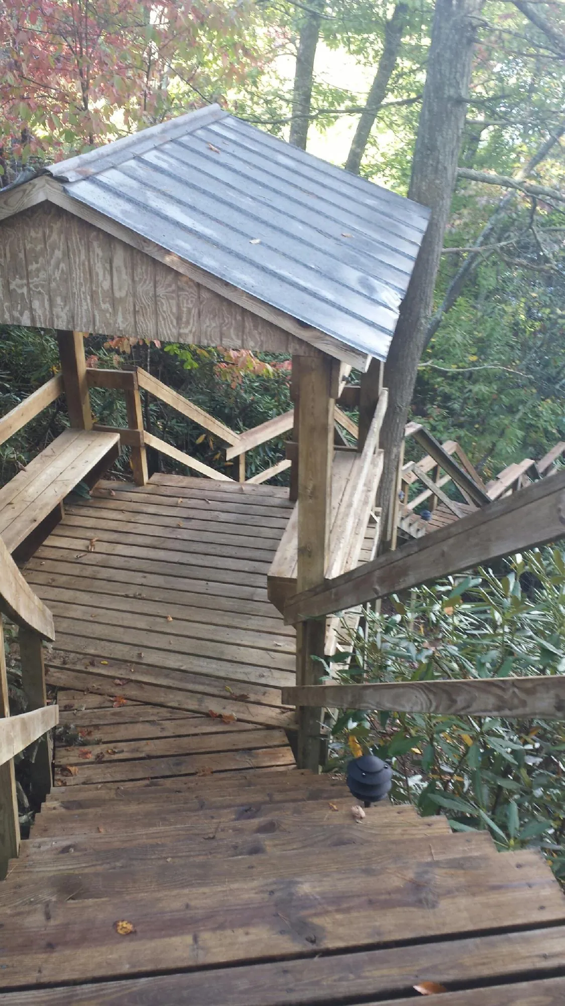 Metal roofed shelter over wooden steps on a wooded walkway — Skylight Repair & Installation work by our crew in Kinsale
